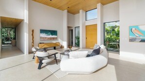 En rummelig opholdsstue med en moderne sofa, et sofabord og et billede på væggen.