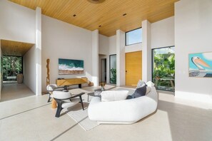 A spacious living area with a modern sofa, a coffee table, and a painting on the wall. - Lingalonga (Guanacaste)