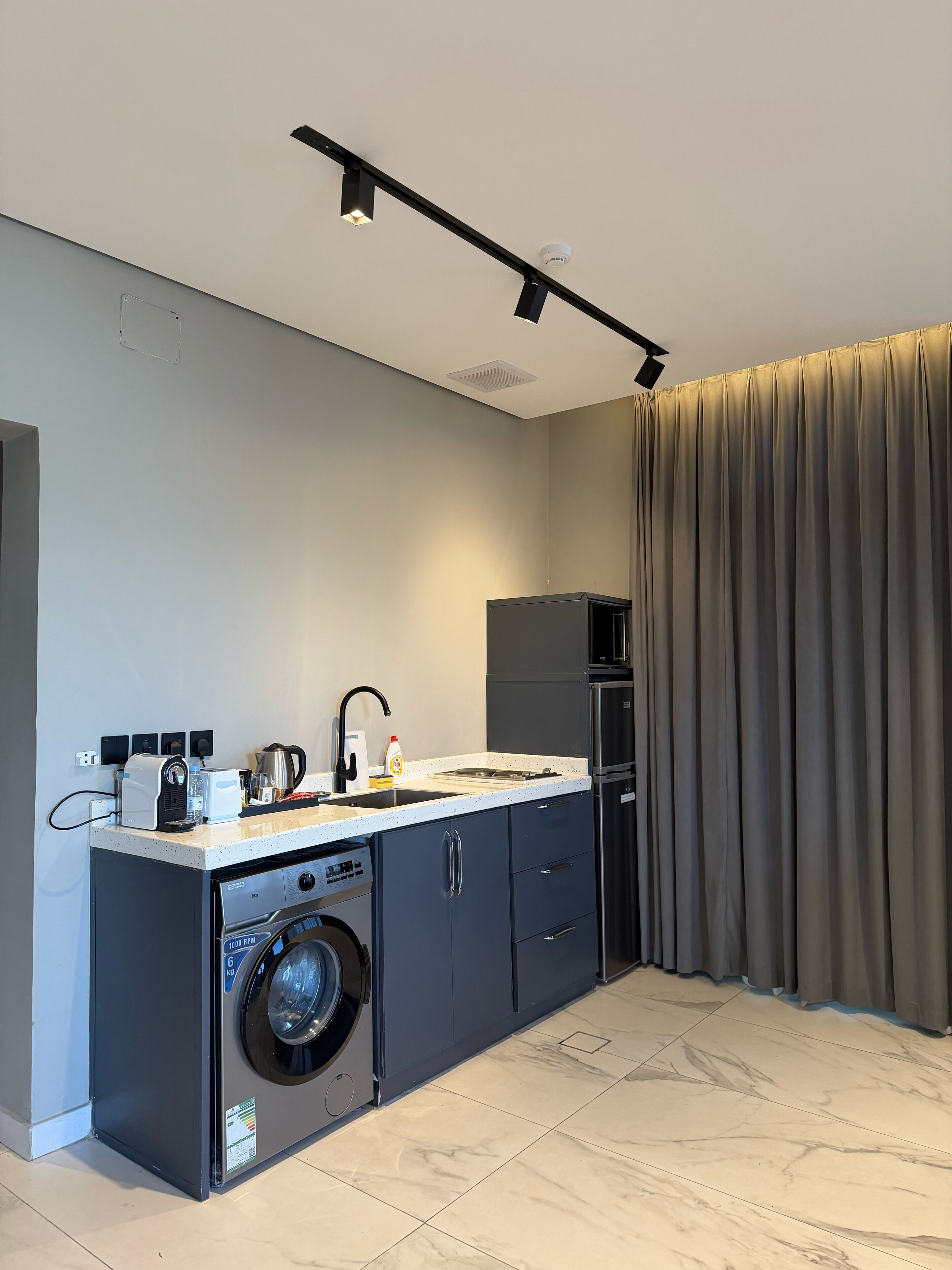 Een mini-koelkast, een magnetron, kookgerei, borden en bestek