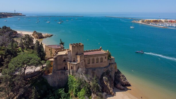A coastal castle with a beach and clear blue sea. - Casa Bayview Bliss - Sea Views, Pool & BBQ, Stroll to Beach and Ferragudo Village (Ferragudo)