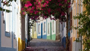 A narrow cobblestone street flanked by colorful buildings with balconies. - Casa Bayview Bliss - Sea Views, Pool & BBQ, Stroll to Beach and Ferragudo Village (Ferragudo)