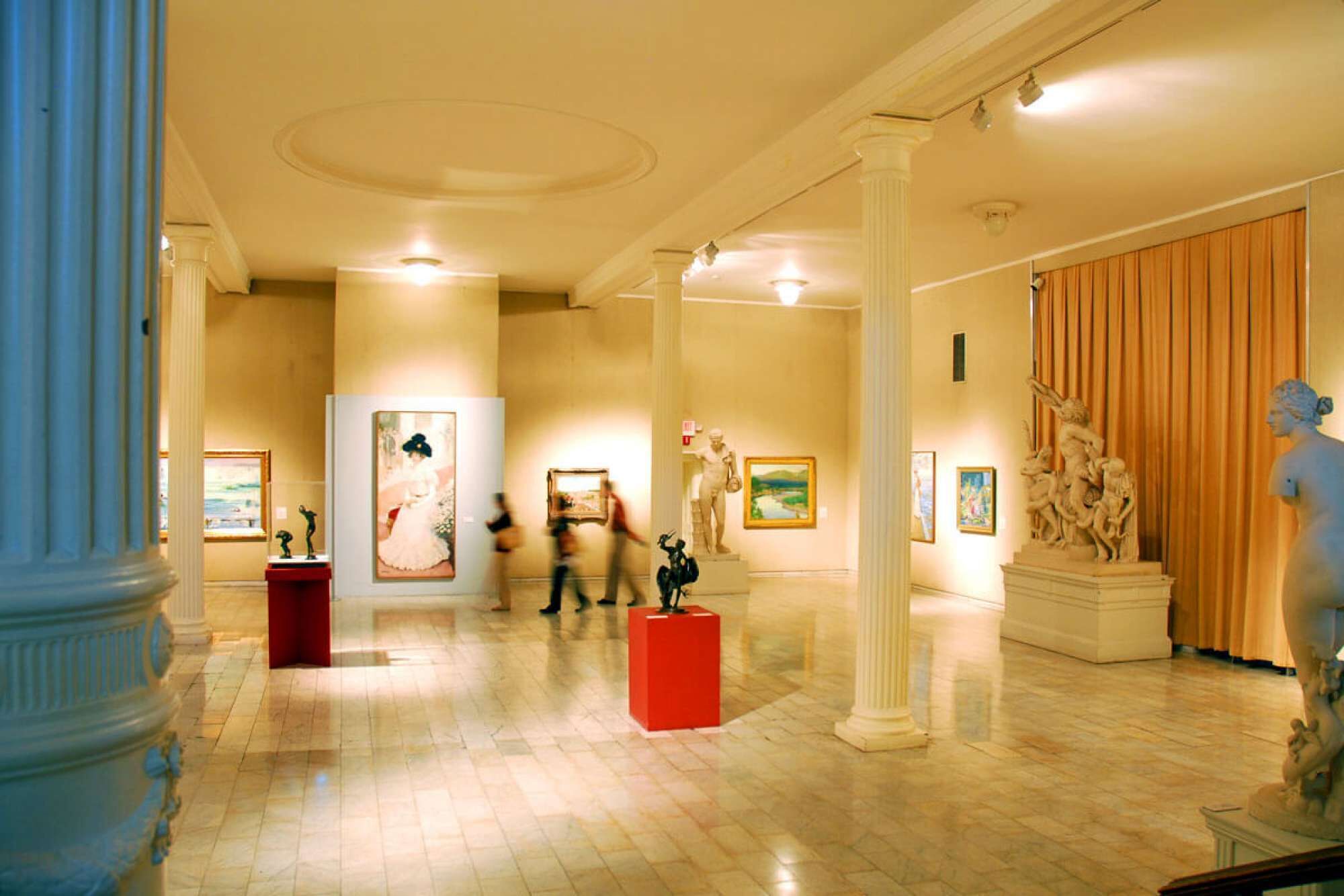 Un hall d’entrée spacieux, doté de sols en marbre, de colonnes classiques et de diverses œuvres d’art exposées sur les murs.