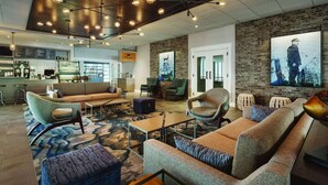 Un espace lounge moderne doté d’un bar, de sièges et d’œuvres d’art.
