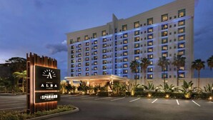 A multi-story hotel with a modern facade, a well-lit entrance, and a landscaped area with palm trees. - Luxury Retreat In Tampa | Free Airport Shuttle (Tampa)