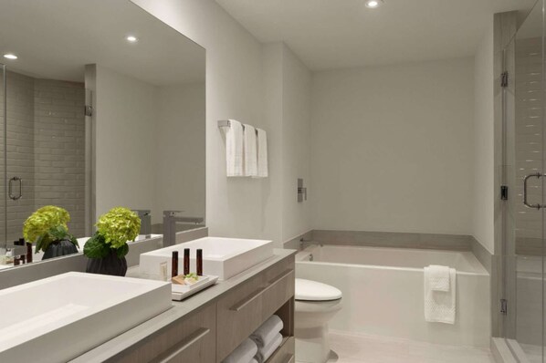 A modern bathroom with a large mirror, two sinks, a toilet, and a bathtub. - Direct Ocean Views + Rooftop Pool. Bar. Tennis. (Hollywood)