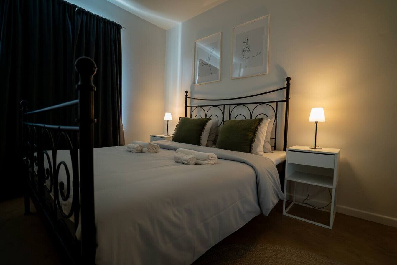 Un lit bien fait, avec des oreillers, une lampe de chevet et une table de nuit.