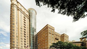 A high-rise building with a curved facade and a cylindrical glass tower. - Atlanta Landmark Stay | Skyline Gym + Full Kitchen (Atlanta)