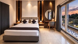 Een moderne slaapkamer met een groot bed, een bureau en uitzicht op de stad.