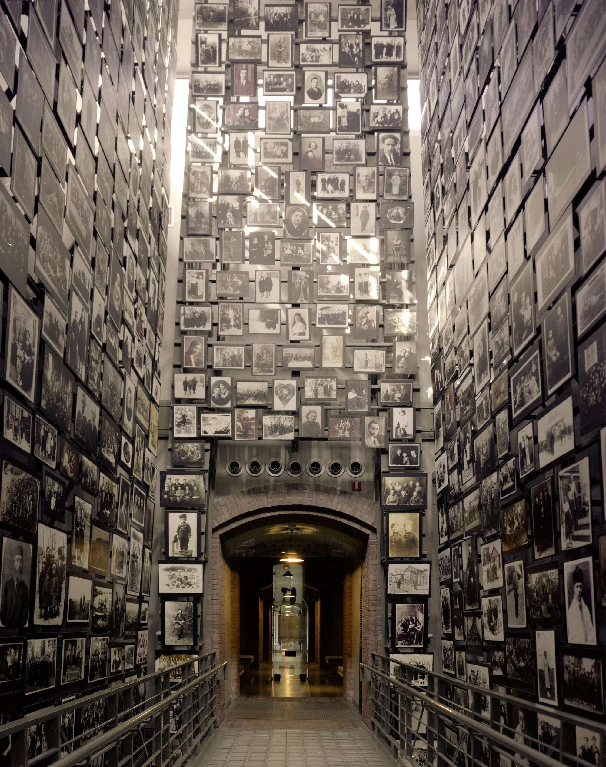 A corridor with walls lined with numerous black and white photographs.
