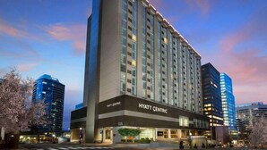Un hotel de varios pisos con diseño moderno, que presenta un llamativo letrero de "Hyatt Centric" en la entrada.