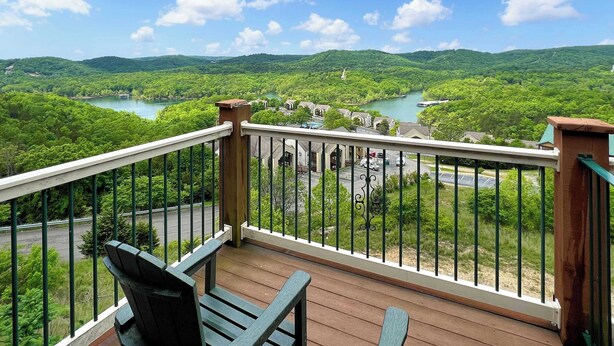 Un balcon avec vue sur une rivière et la verdure.