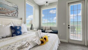 Une chambre à coucher avec un lit, un tableau, une fenêtre avec des stores et une porte.