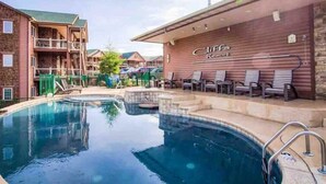 A hotel with a pool area, outdoor seating, and a building with a sign that reads "Cliffs Resort." - L-8 Stunning views close to SDC (Branson)