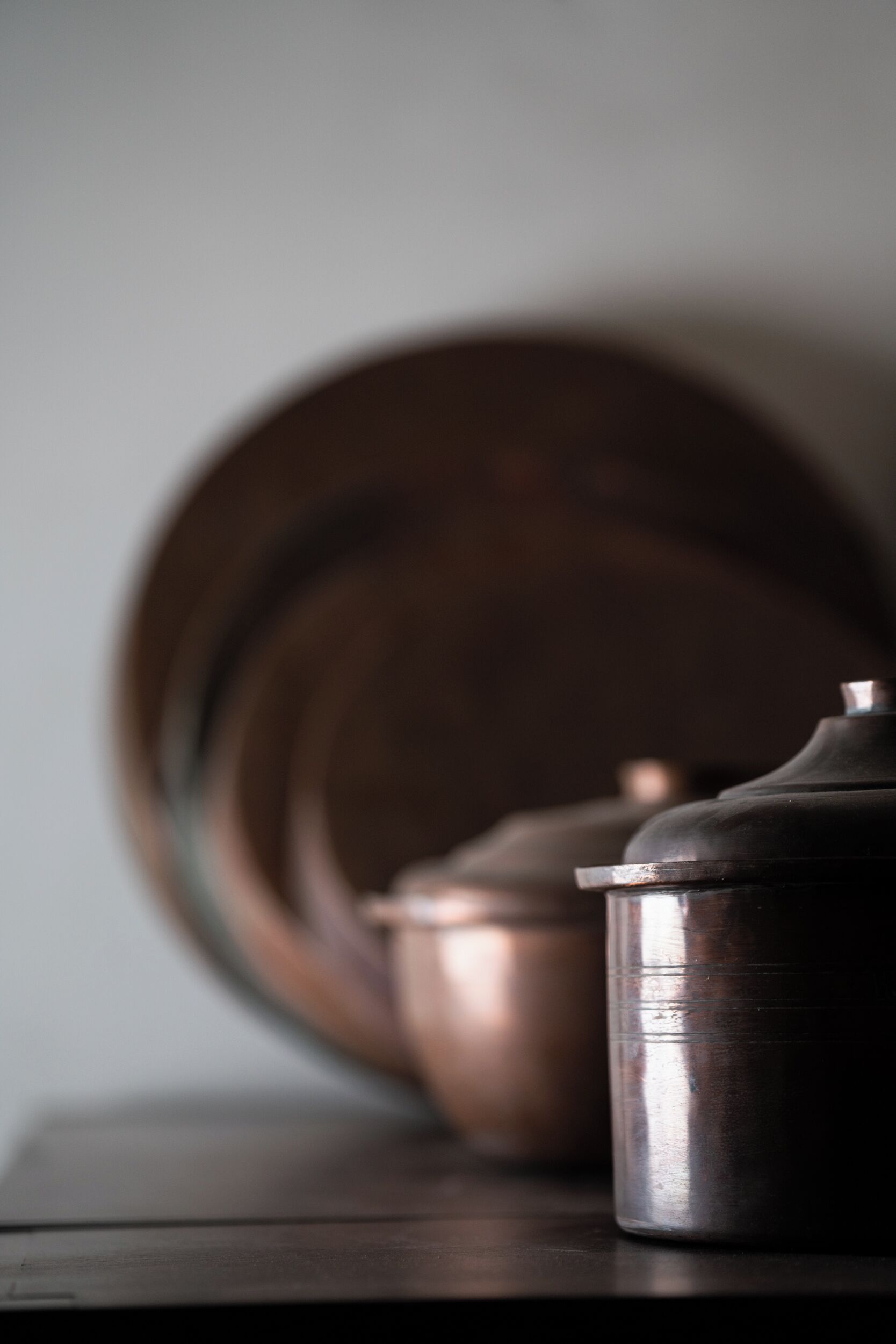 A close-up of a metallic container on a wooden surface with a blurred background.