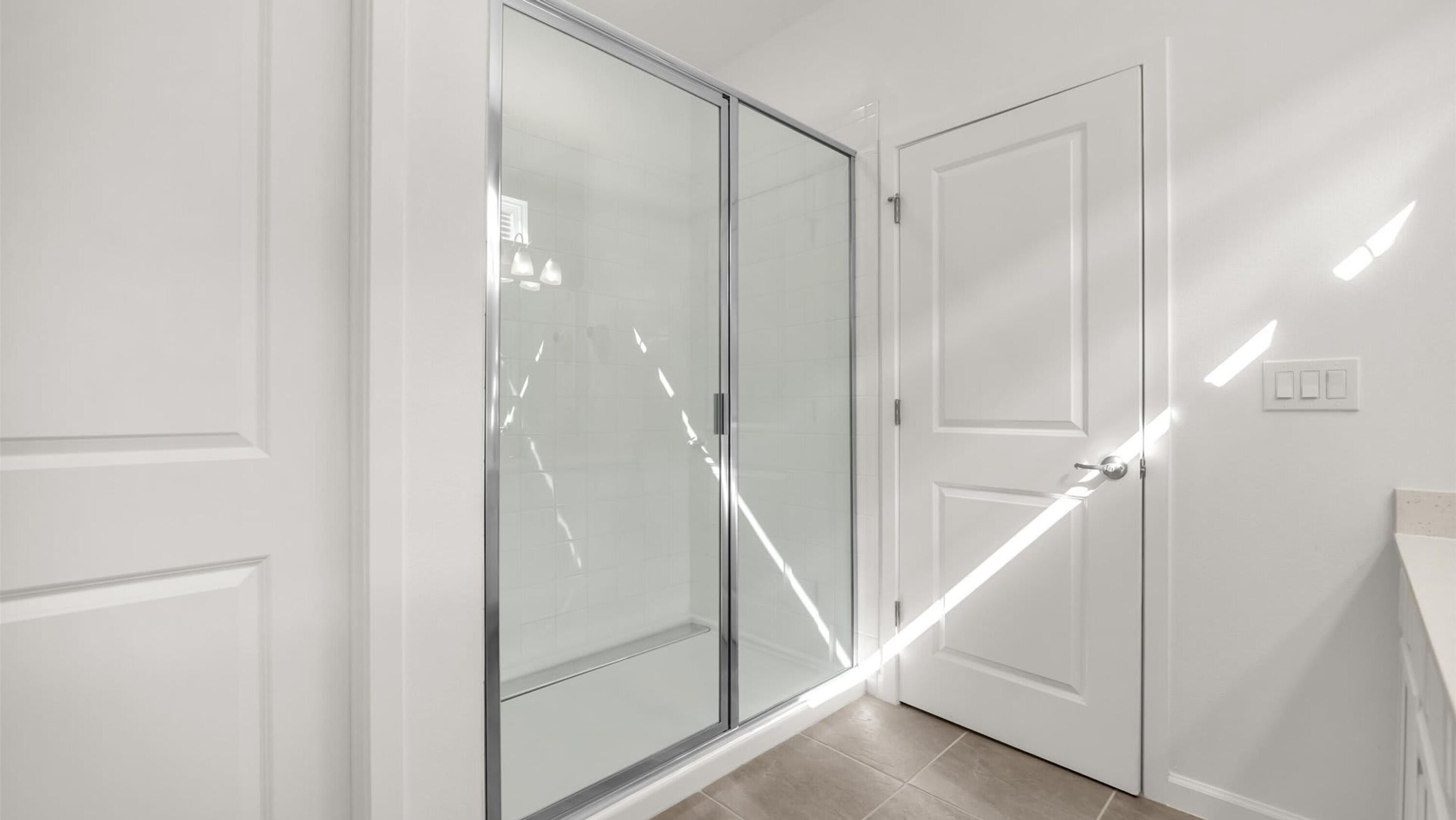 A hallway with a sliding glass door leading to a bathroom.
