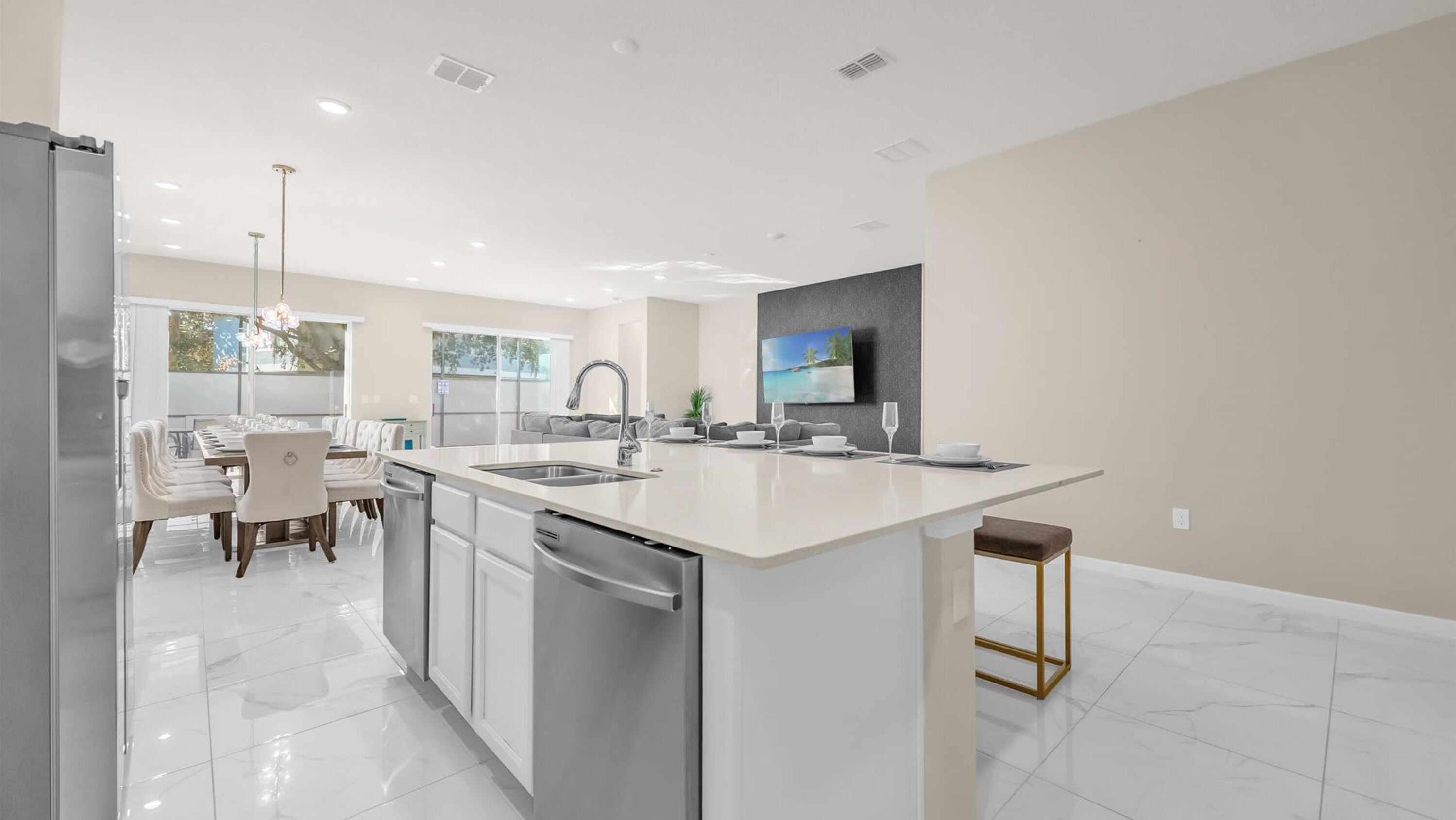 A modern kitchen with a central island, stainless steel appliances, and a dining area with a long table and chairs.