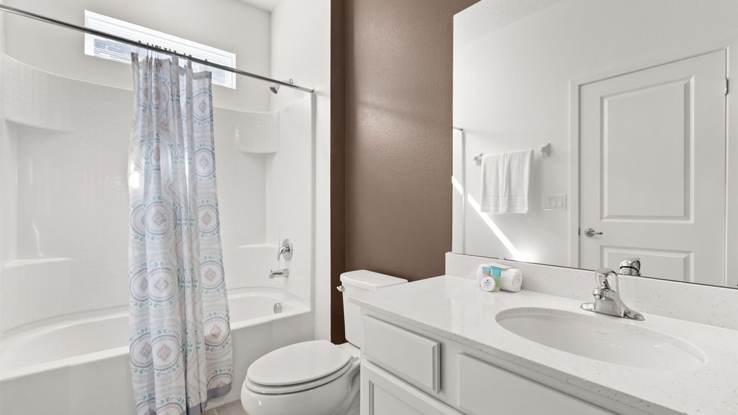 A bathroom with a shower, toilet, and sink.
