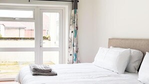 A hotel room with a bed, a window, and a view of the outside. - 58A Thorpe Road, Norwich (Norwich)