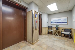 An elevator, a reception area with a painting, and seating. - Fun w/ Family! Sugartop Gem w/ Pool + Mtn Views (Banner Elk)