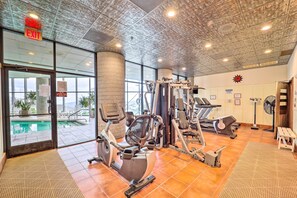 A gym with various exercise equipment, a pool visible through the glass doors, and a ceiling with a unique design. - Fun w/ Family! Sugartop Gem w/ Pool + Mtn Views (Banner Elk)