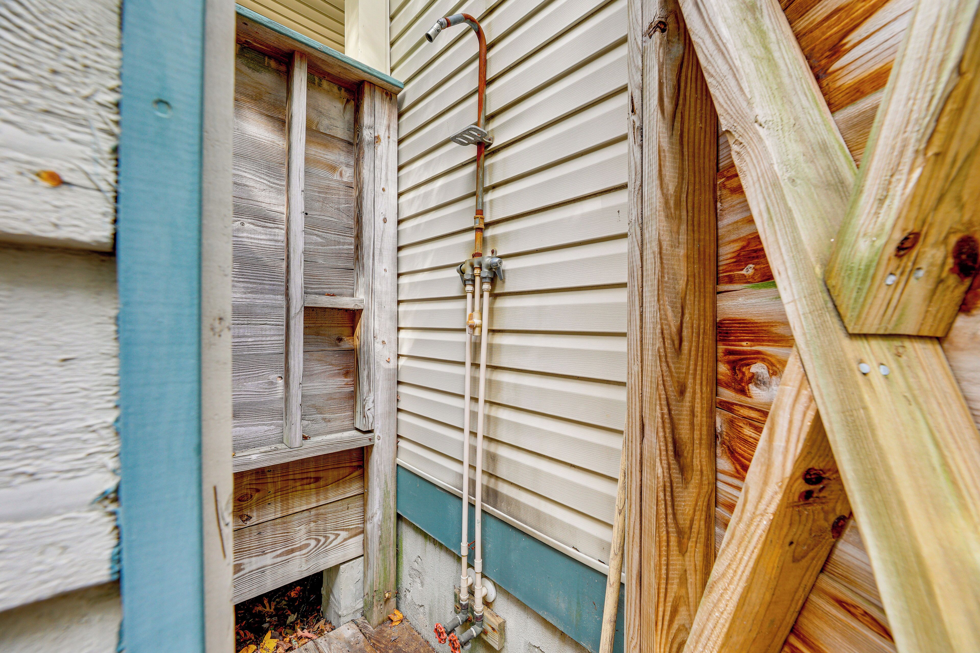 A corner of a building with wooden siding and a metal pipe running vertically.