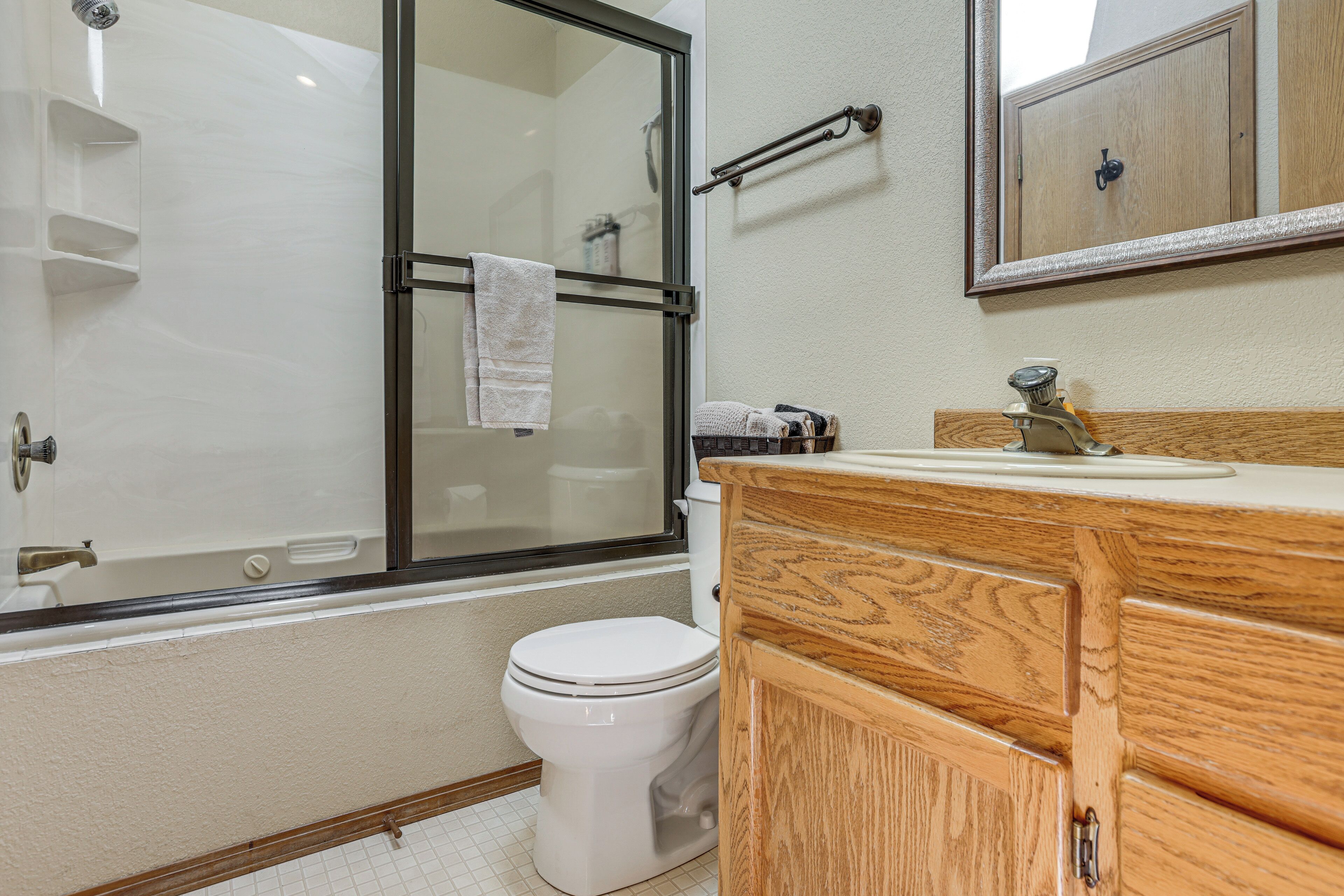 A bathroom with a glass shower enclosure, a white toilet, and wooden cabinetry.