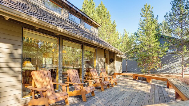 A wooden deck with Adirondack chairs and a bench, overlooking a forested area. - Private Hot Tub & Sharc Passes! Sunriver Home (Bend)