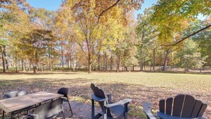 Een park met een picknicktafel en stoelen, omringd door bomen met herfstkleuren.