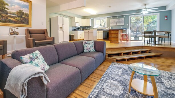 Een moderne woonkamer met een bank, een glazen salontafel en een vloerkleed.