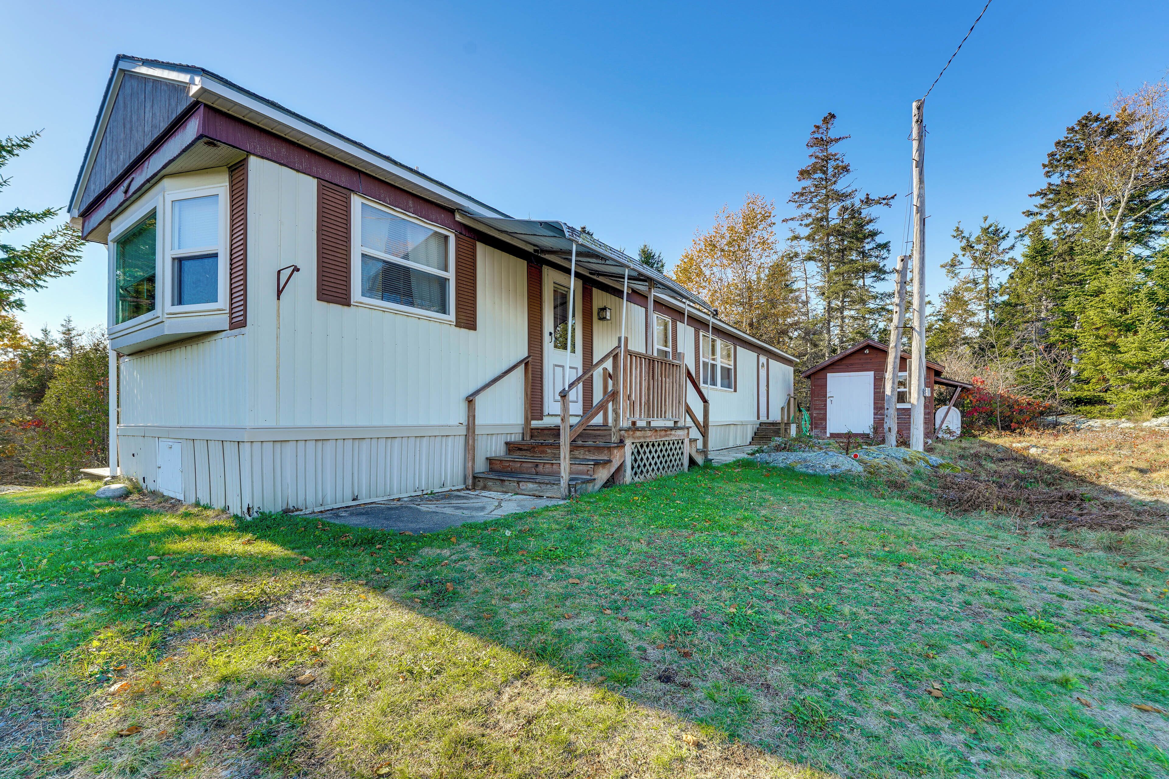A single-story mobile home with a front porch and a small attached garage.