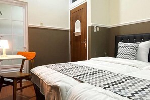 A bedroom with a bed, a desk, and a chair. - Griya Inn (Tembalang)