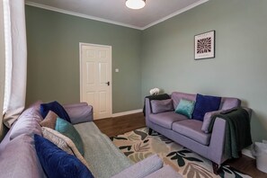A living room with a sofa set, a patterned rug, and a door. - Toast Stays - The Northern View (Sherburn Hill)