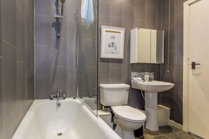 A modern bathroom with a bathtub, toilet, and sink. - Toast Stays - The Northern View (Sherburn Hill)