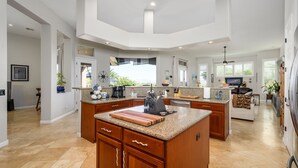 A spacious kitchen with granite countertops, wooden cabinets, and a central island. - A Desert Oasis w/ 4 Peaks Mountain Views! (Scottsdale)