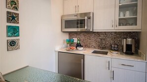 A compact kitchen with a microwave, coffee maker, and a dishwasher. - The Rod and Reel Resort-Suite 3 (Anna Maria)