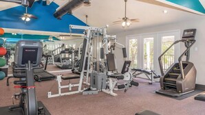 Un gimnasio con diferentes equipos de ejercicio, incluyendo cintas de correr y máquinas de pesas.