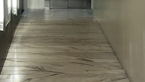 A hallway with a marble floor leading to a metallic elevator. - Sea sunrise (Guardamar del Segura)