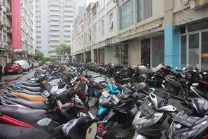 A street lined with parked scooters and motorcycles. - Daddy's Room Apartemen City Park (West Jakarta)