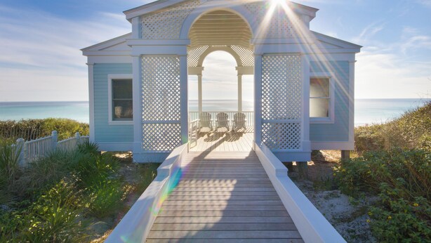 Une maison de plage dotée d’un porche abrité et offrant une vue sur l’océan.