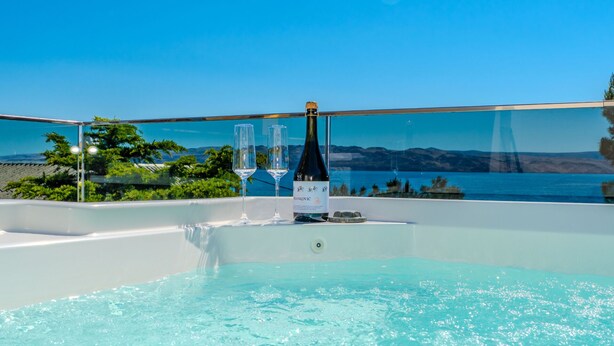 Una piscina con vistas despejadas al mar y montañas al fondo.