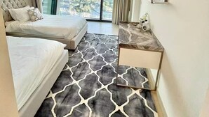 Habitación de hotel moderna con una cama grande, un escritorio y vistas a la ciudad.