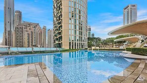Una piscina con borde de azulejos, rodeada de un sendero pavimentado.