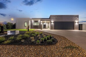 A modern house with a driveway, a well-maintained garden, and a garage. - 37 Sand Piper - Echuca Holiday Homes (Moama)