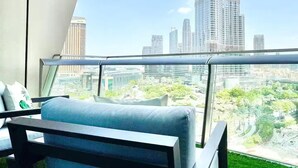 Ein Balkon mit Blick auf den Burj Khalifa, ein moderner Stuhl und künstliches Gras.