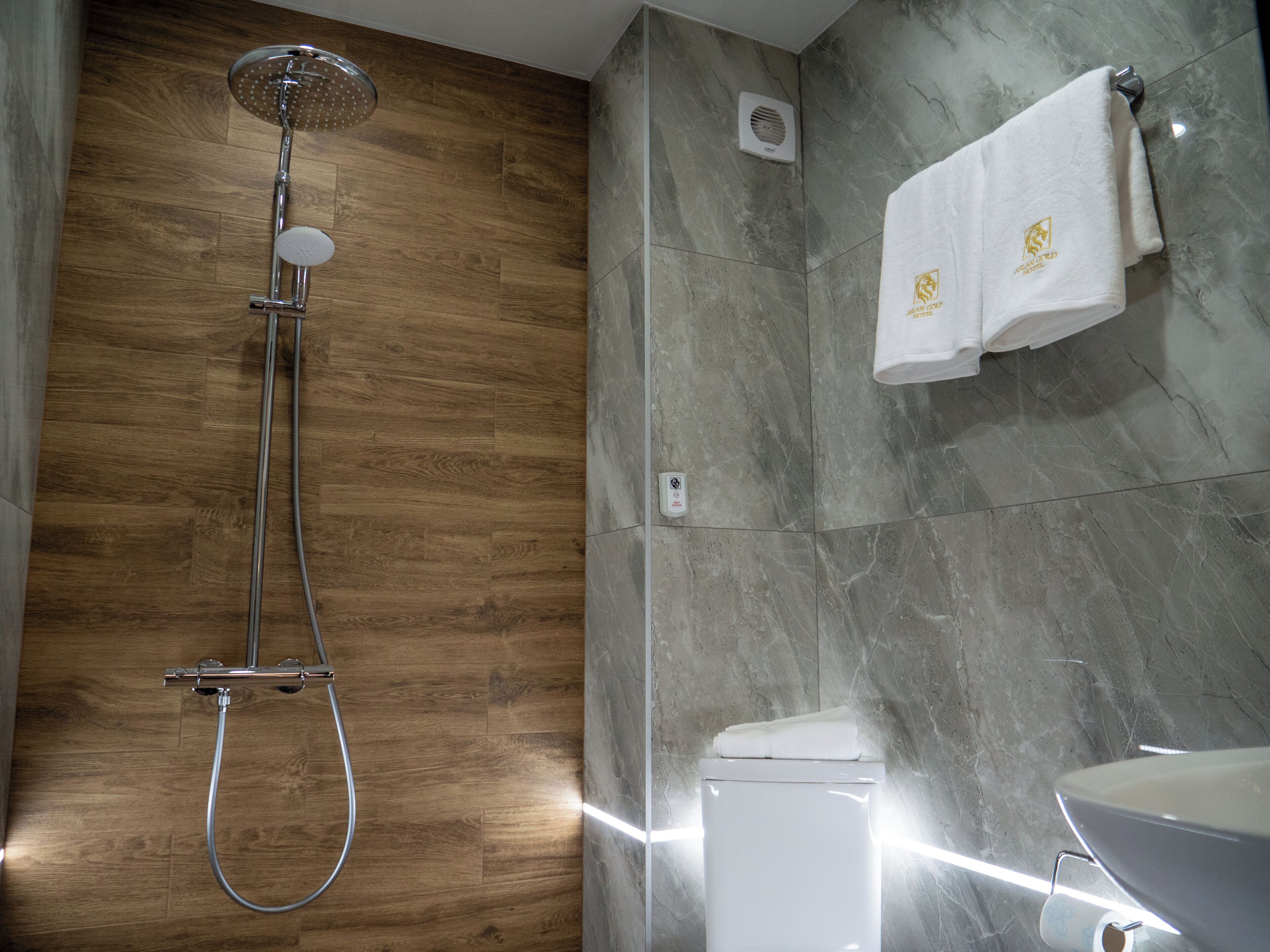 A modern bathroom with a shower, toilet, and sink.