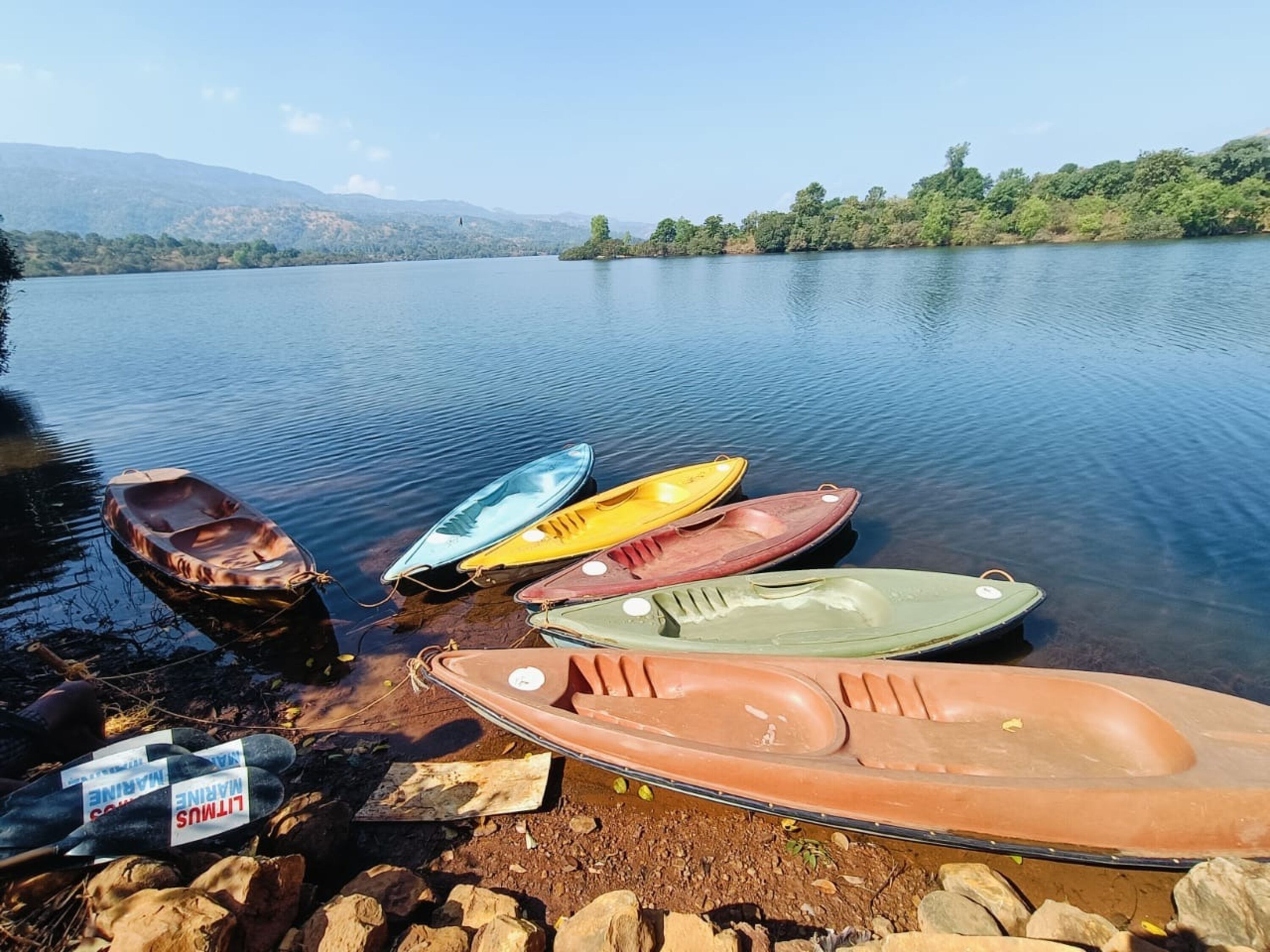 A calm lake with several boats docked at the shore.