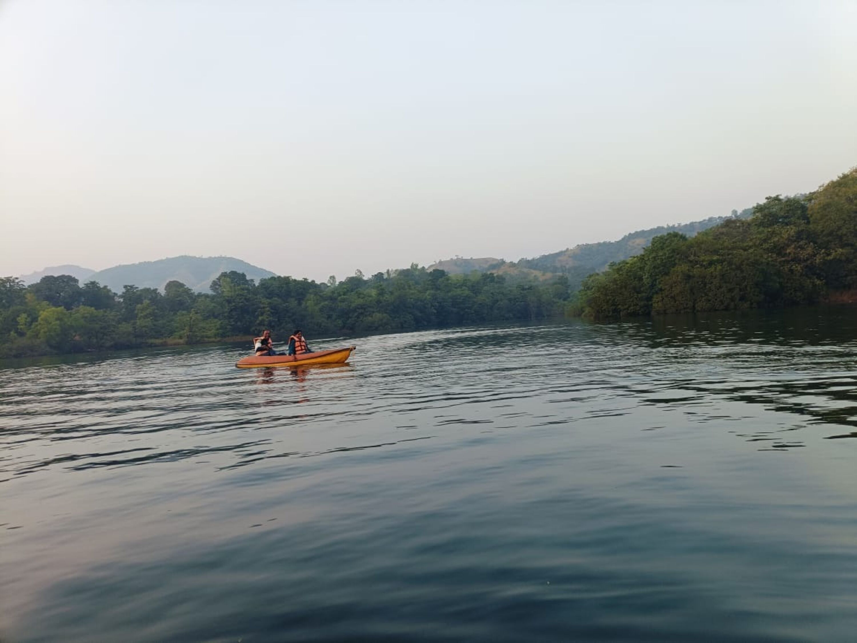 A calm river with a small boat carrying two people.
