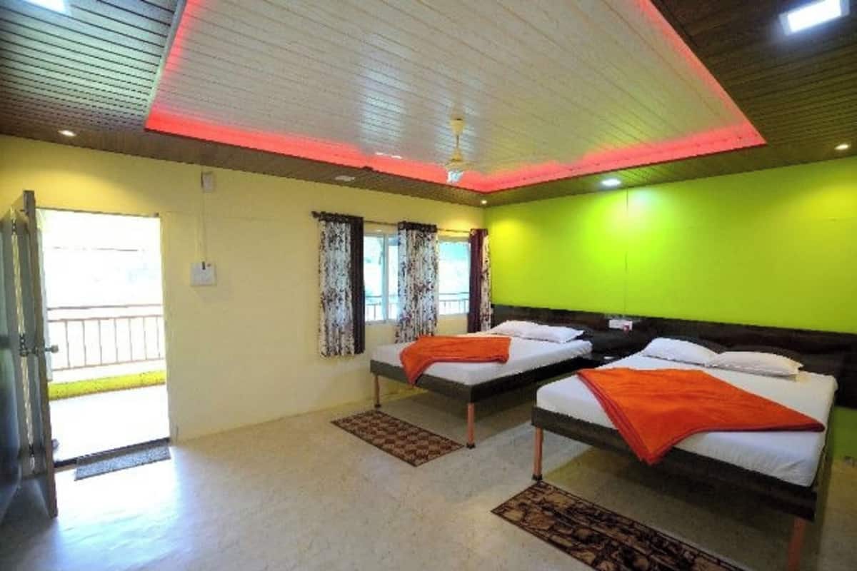 A room with two beds, a ceiling fan, and a view of the outside.