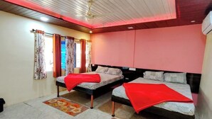 A bedroom with two beds, a ceiling fan, and a window with curtains. - OMKAR AGRO TOURISM AND RESORT (Mahabaleshwar)