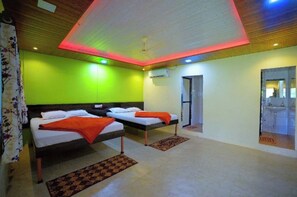 A hotel room with two beds, a ceiling fan, and a bathroom visible through an open door. - OMKAR AGRO TOURISM AND RESORT (Mahabaleshwar)